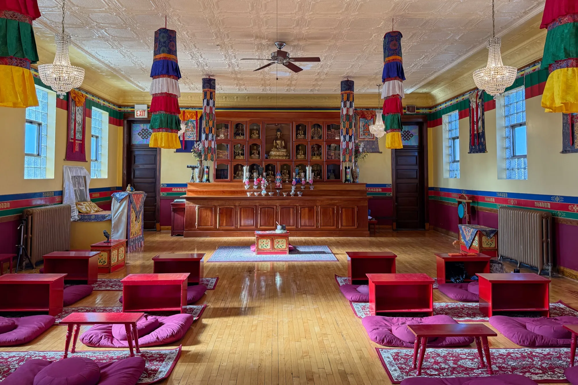 The Chicago KTC shrine room, ready for Sunday practice — low red tables, maroon cushions, and the shrine cabinet at the front