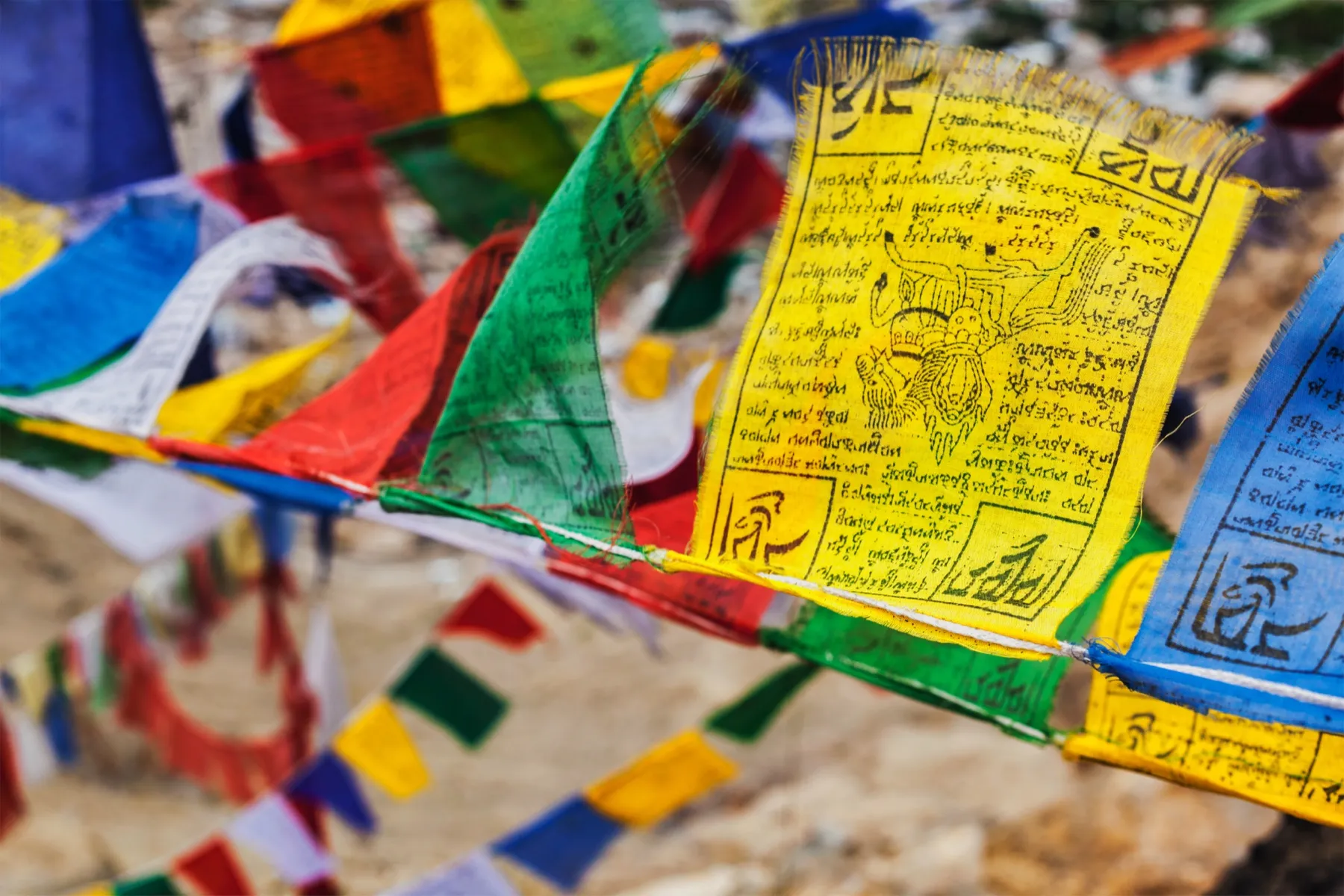 Colorful Tibetan prayer flags printed with mantras, fluttering in the wind